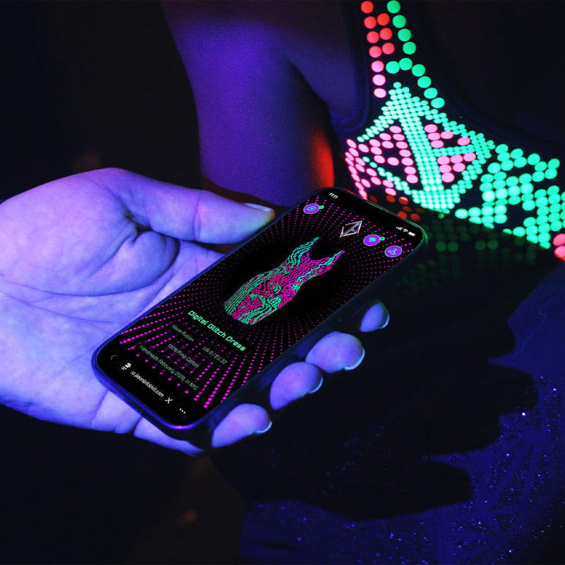 Person wearing a Jason Brickhill garment activating the built-in NFC tag with a smartphone to unlock the digital experience under UV light.