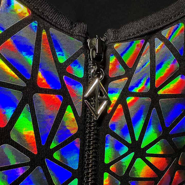 Close-up of silver holographic mosaic zipper detail with rainbow reflective panels and geometric black trim.
