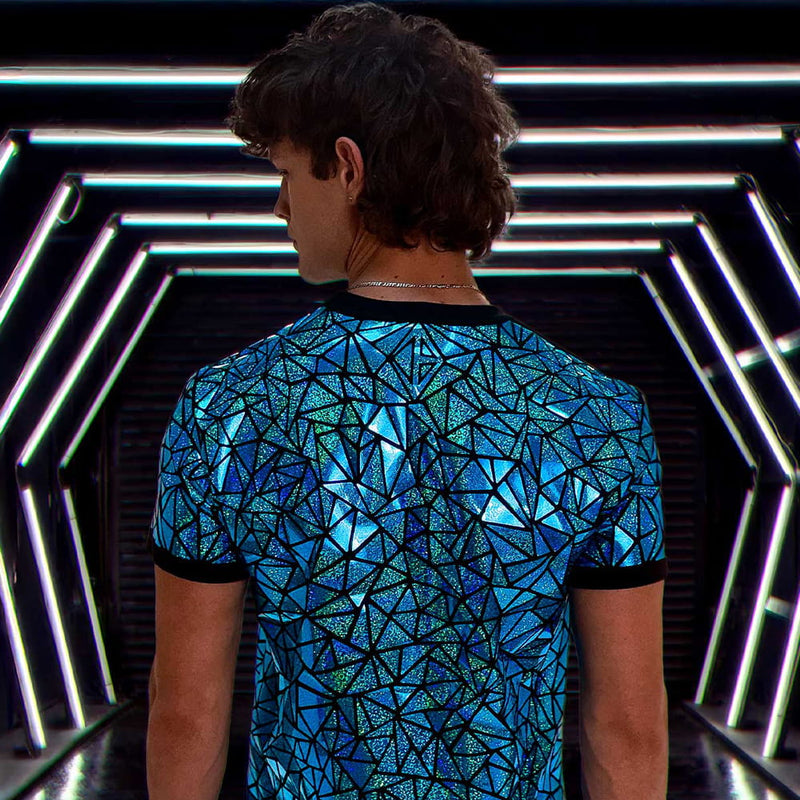 Person wearing a blue holographic mosaic T-shirt under neon lighting.